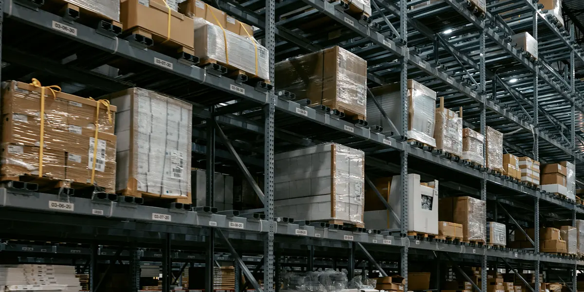 Palettes de cartons filmées sur les rayonnages d’un dépôt.