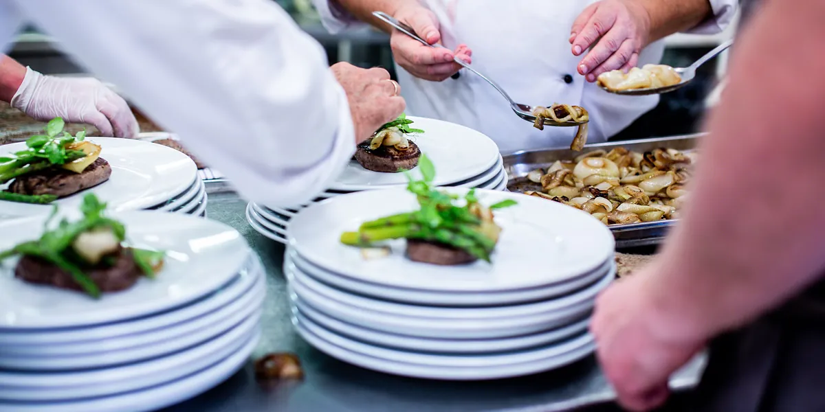 Dressage en cuisine pendant le service&nbsp;: des assiettes empilées et le même plat répété.